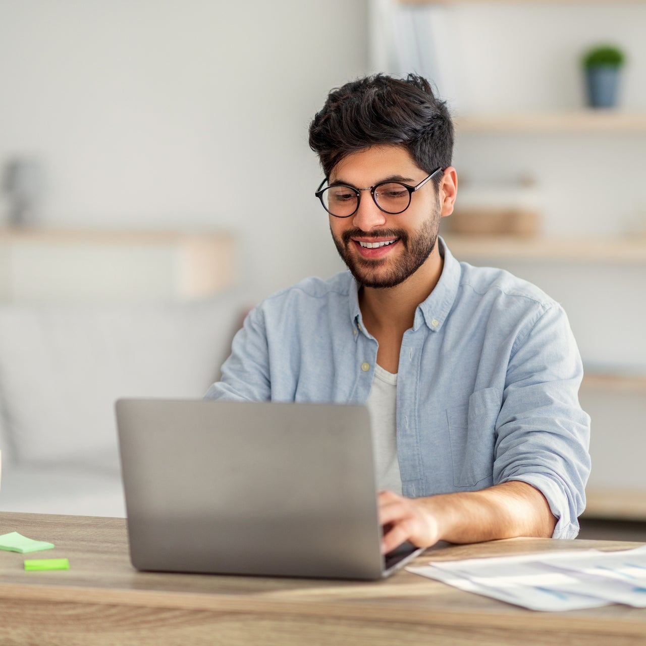 A professional young man using their computer to do a credit check.
