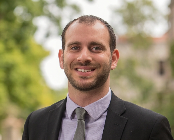 A headshot of Asaf Bernstein in a suit.