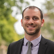 A headshot of Asaf Bernstein in a suit.