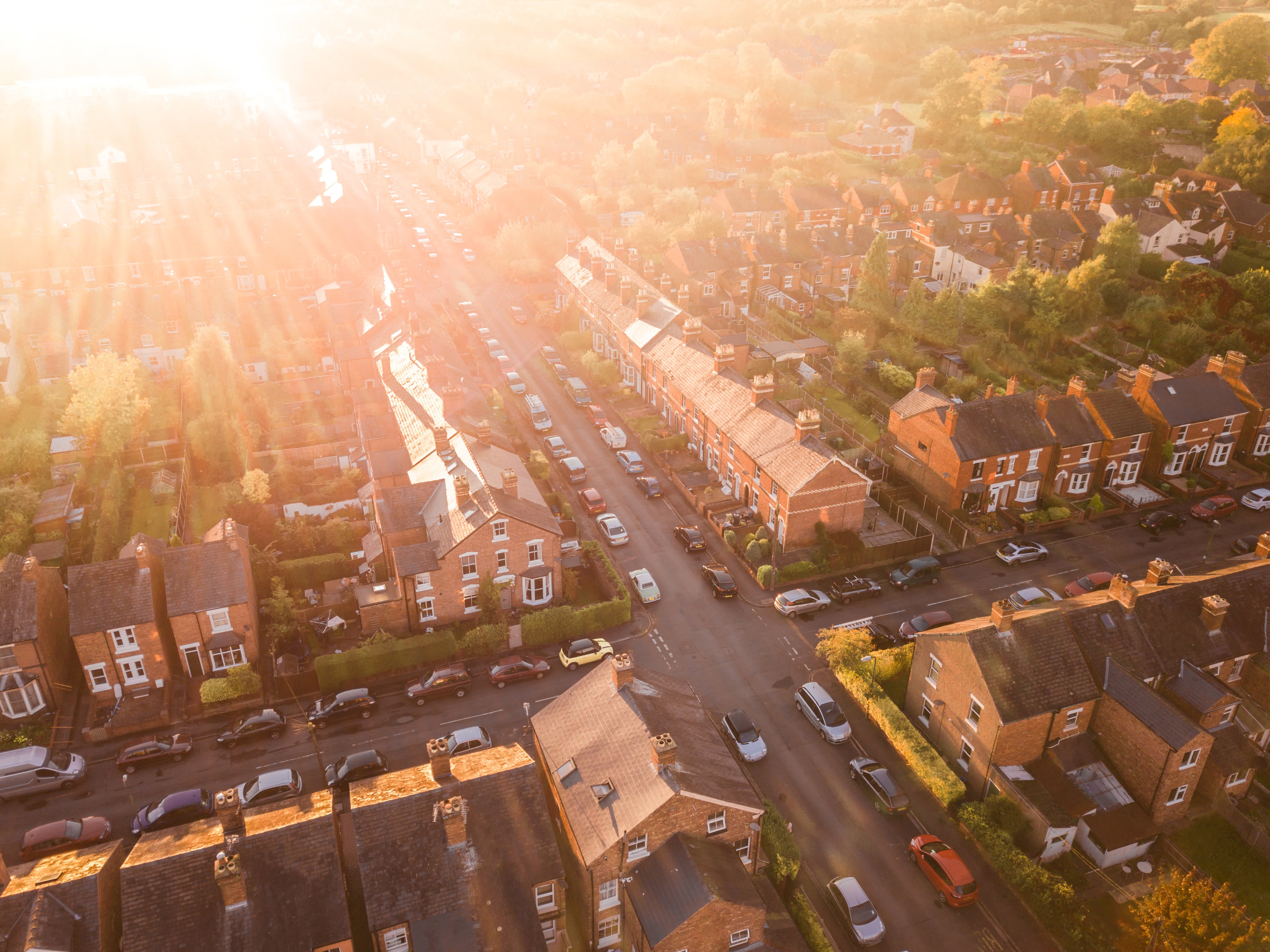 An aerial view of a residential neighborhood with rows of houses and cars lining the streets.