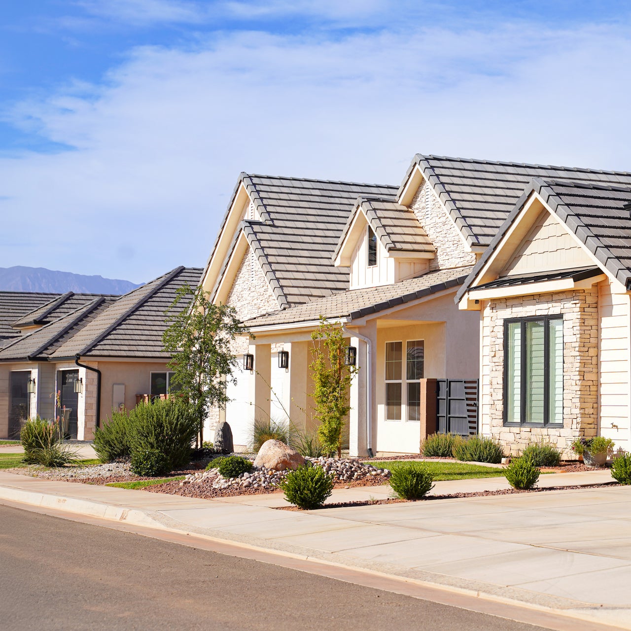 A row of modern houses with dark roofs.