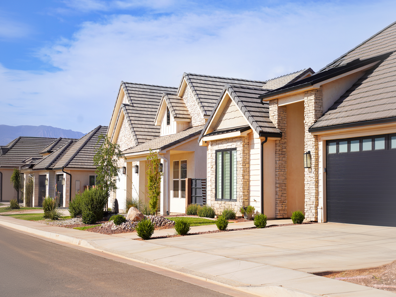 A row of modern houses with dark roofs.