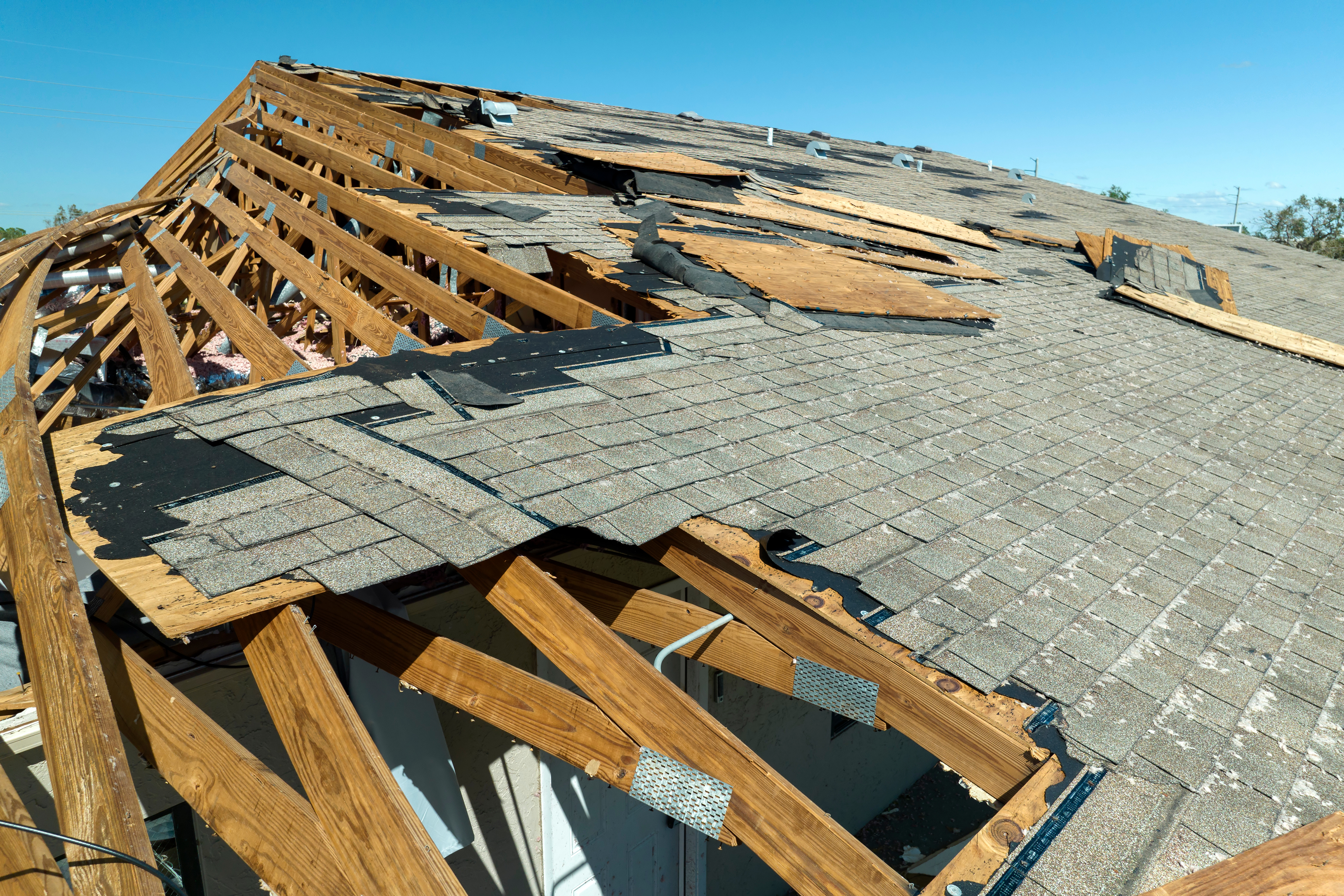 A view of a damaged roof, likely due to strong winds or a storm. 