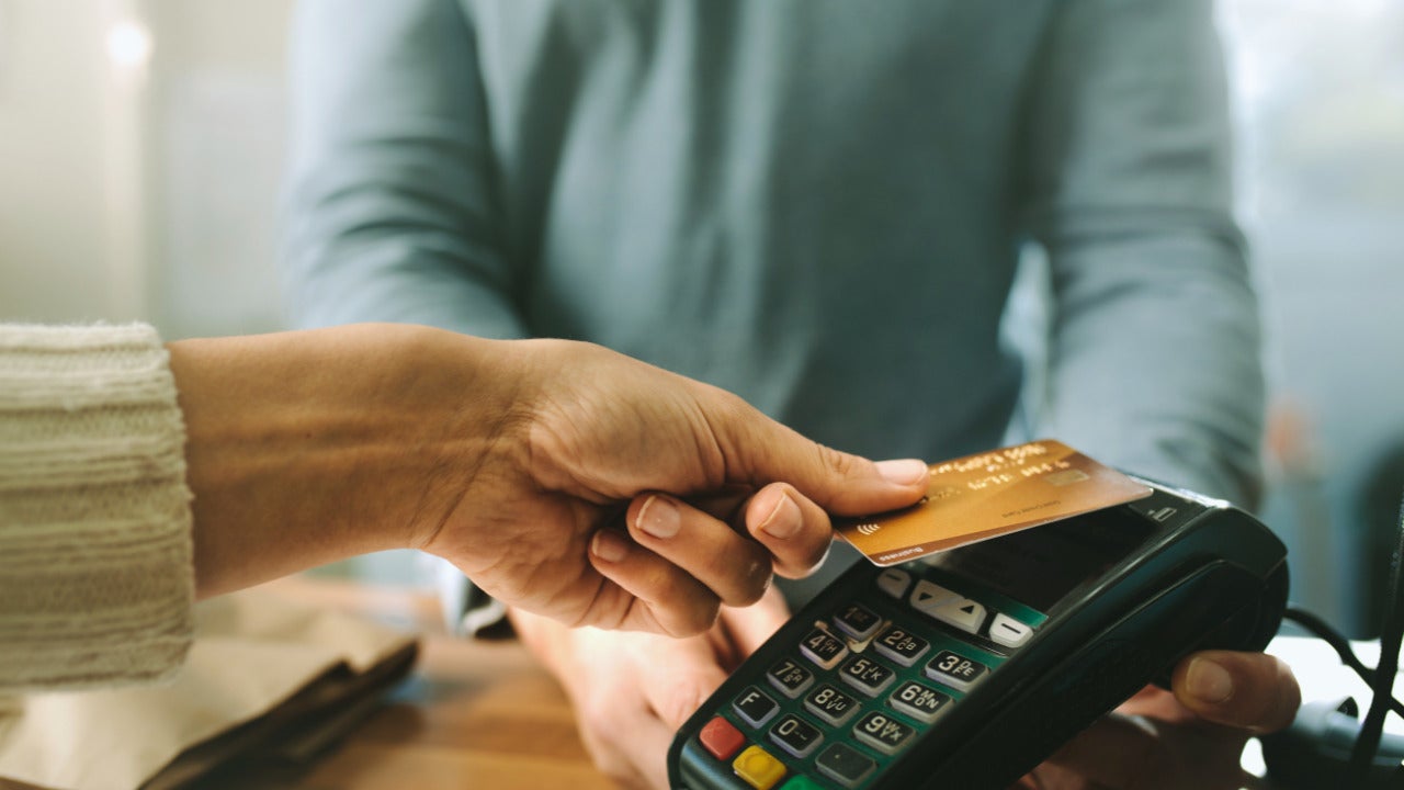 Someone tapping a credit card to pay