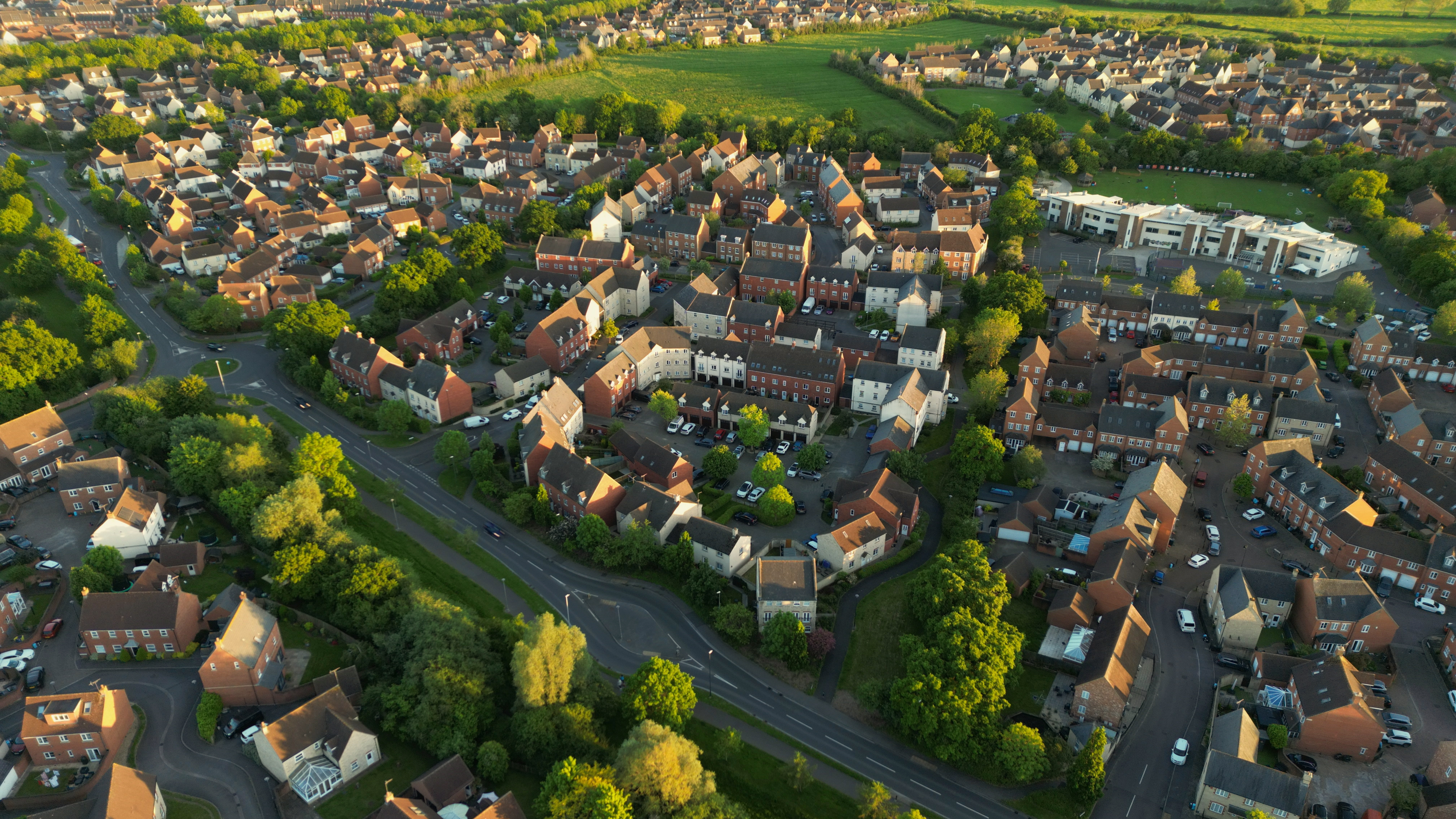 An aerial view of a well planned residential neighborhood with bunch of houses and greenery around.