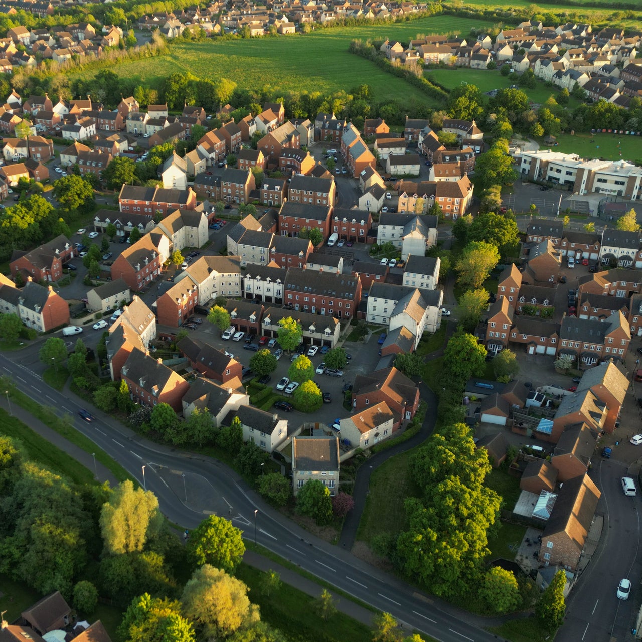 An aerial view of a well planned residential neighborhood with bunch of houses and greenery around.