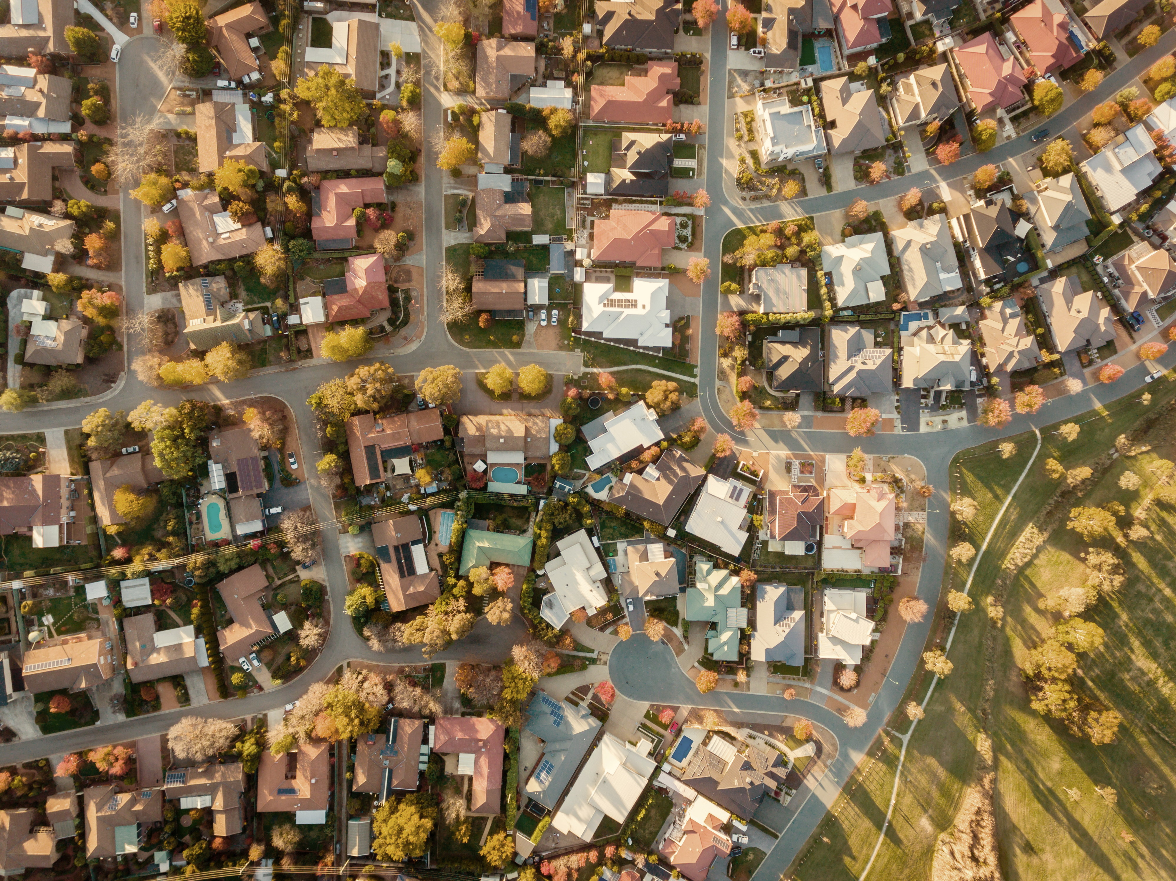 An aerial view of a residential neighborhood with greenery around.