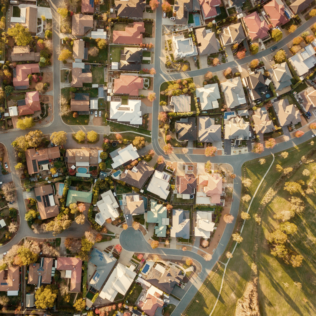 An aerial view of a residential neighborhood with greenery around.