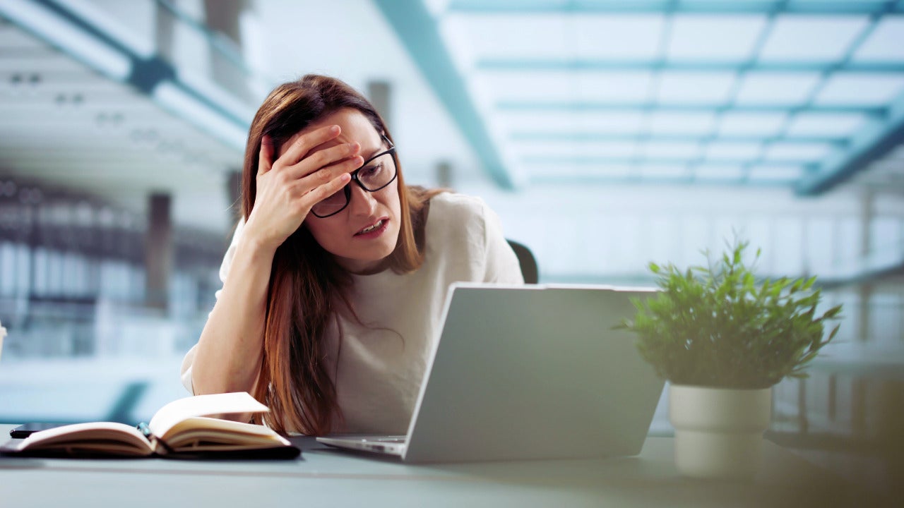 A woman who looks distraught and upset, possibly because she was the victim of a cybercrime