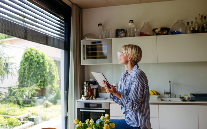 Homebuyer reading her ipad and looking out the window.