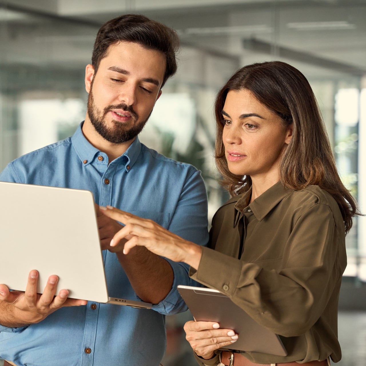 Two participants of the property insurance claims process collaborating while looking at a laptop
