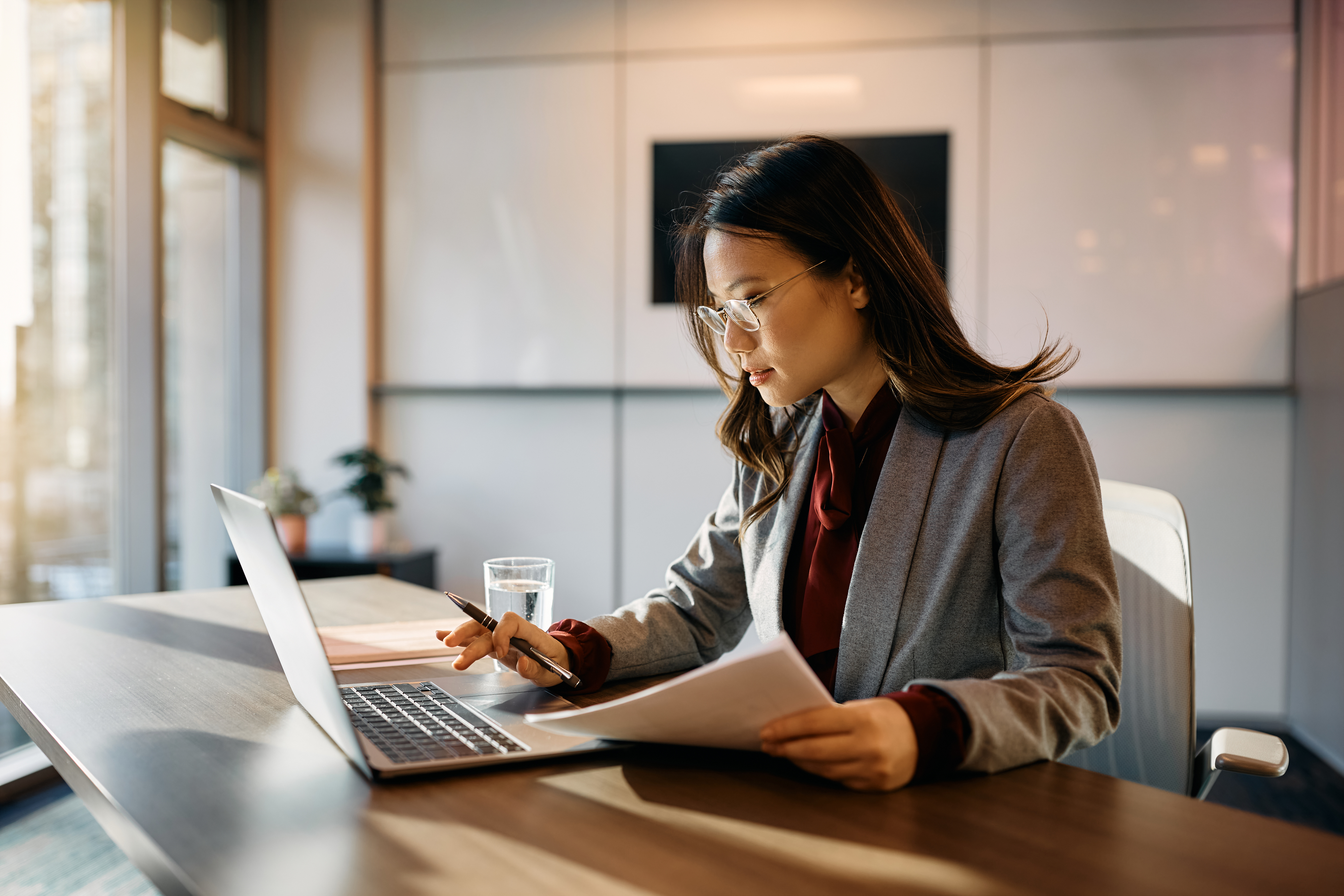 A professional is seen working on her laptop.