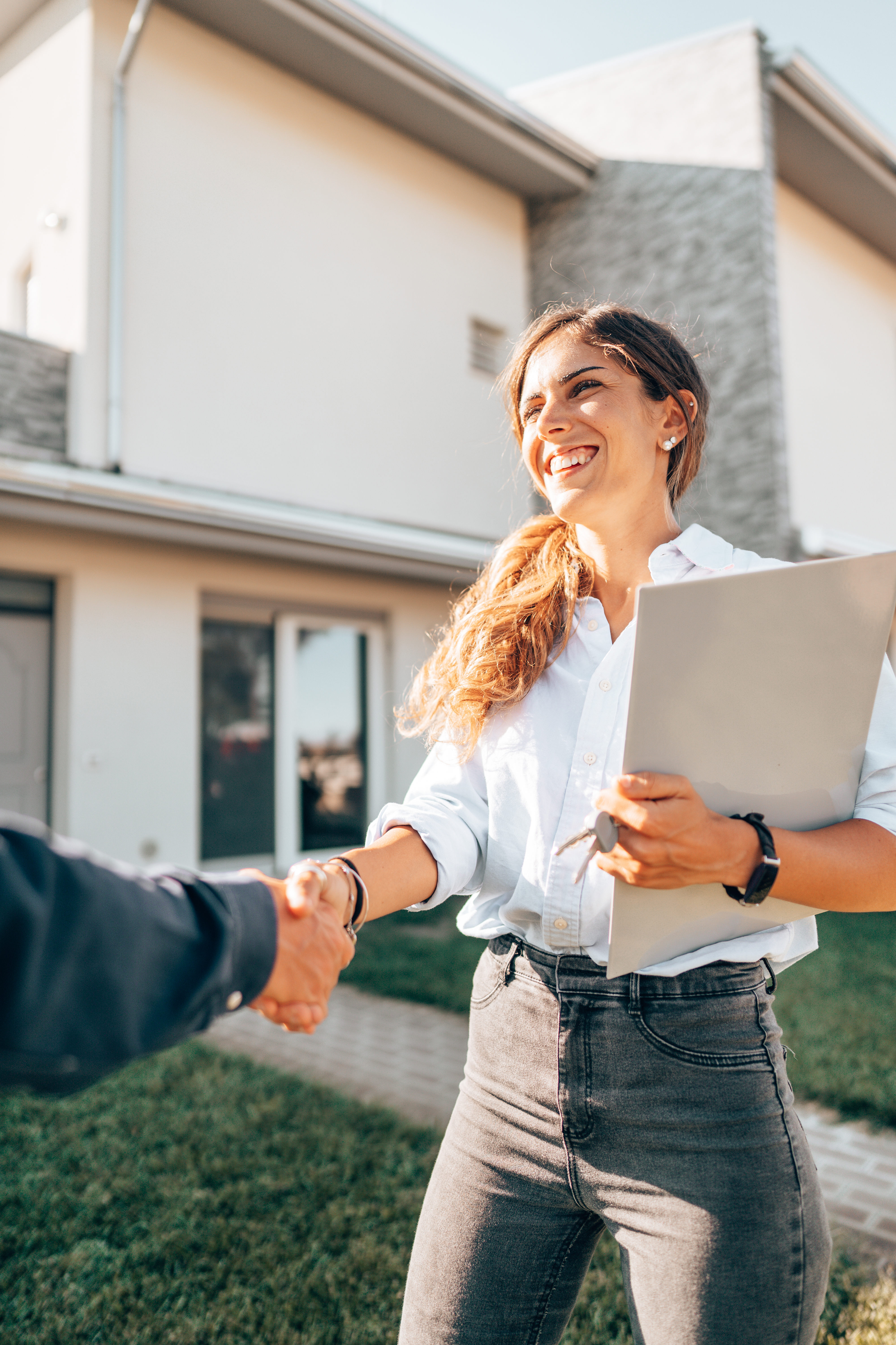 A real estate agent is seen handing over house keys to a client after a successful property sale. 