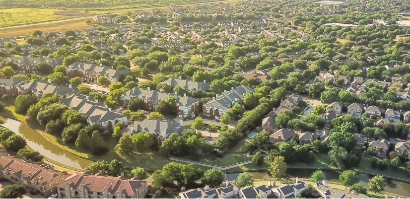 A modern, high-tech presentation room with a large curved digital screen displaying various data and graphics, with a person standing in front of the screen and another person seated at a desk facing it.