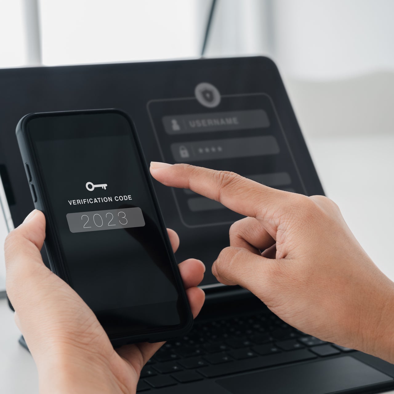 Someone using a computer and getting a multi factor authentication code for security.