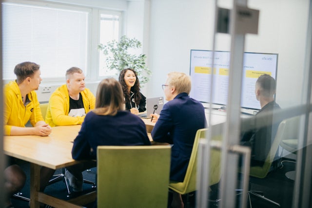 A man wearing a yellow hoodie holding a representation of AI in his hand