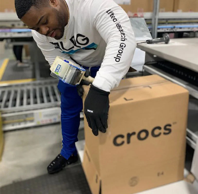 Crocs distribution a man taping a box
