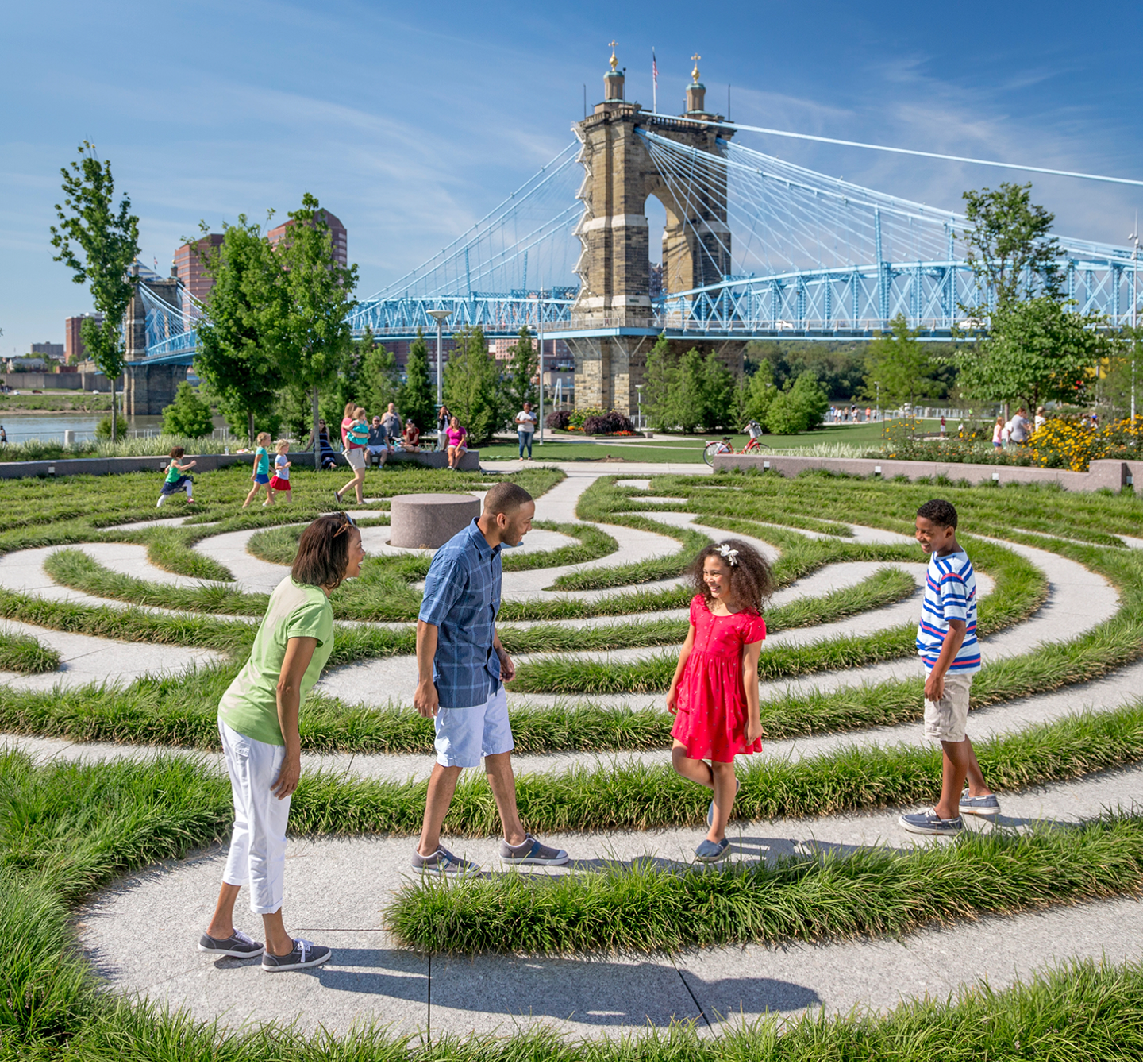 A family of four exploring a winding path near a bridge