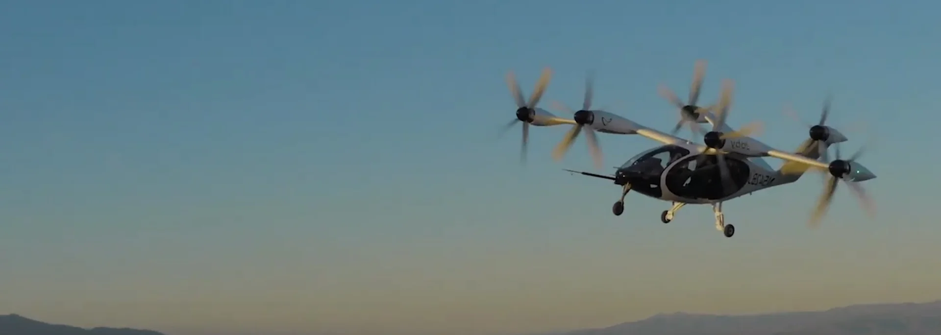 Advanced aircraft flying with mountains in the distance