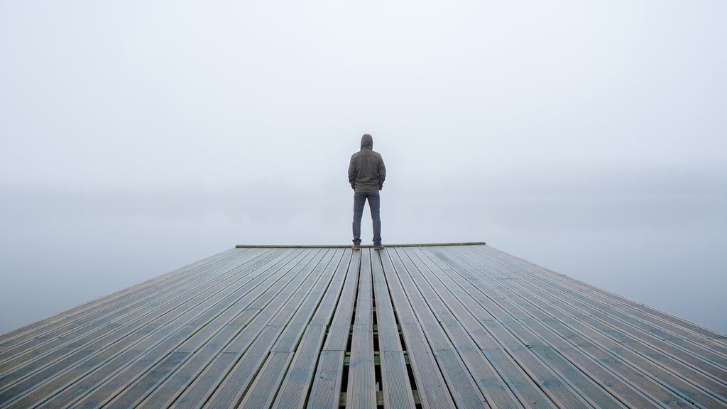 man at the end of a peer on a foggy day