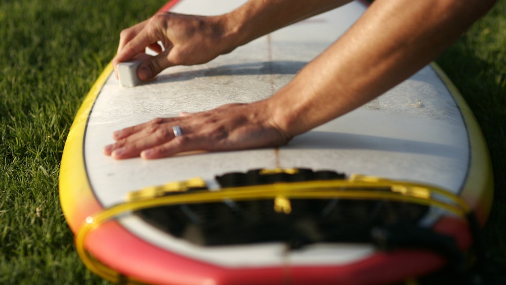 surfer waxing his board