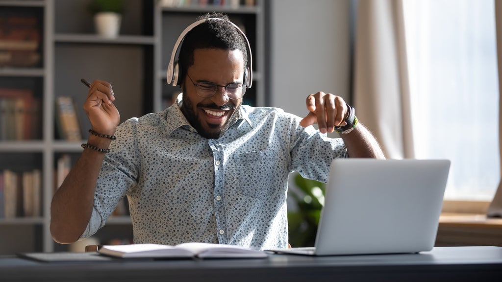 man listening to music and dancing on his seat at the office