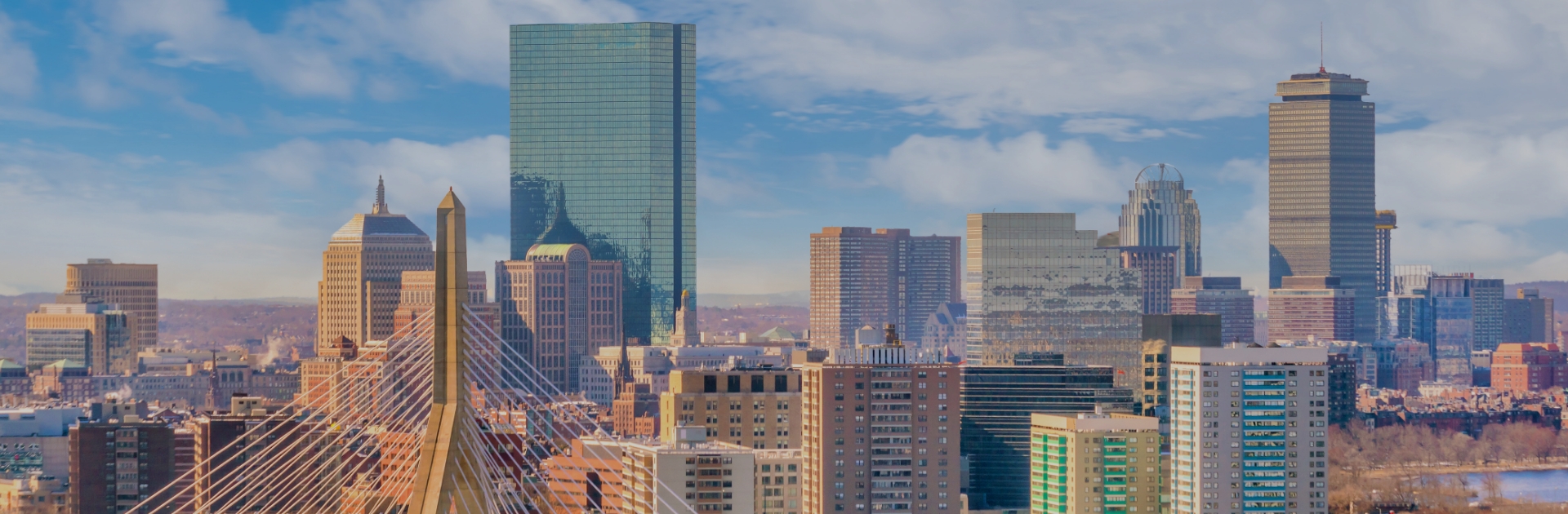 Skyline view of Boston, Massachusetts with the Zakim Bridge in the foreground and high-rise buildings under a partly cloudy sky. SHL Medical will exhibit at PODD 2025 in Boston, USA, Booth #305-306.