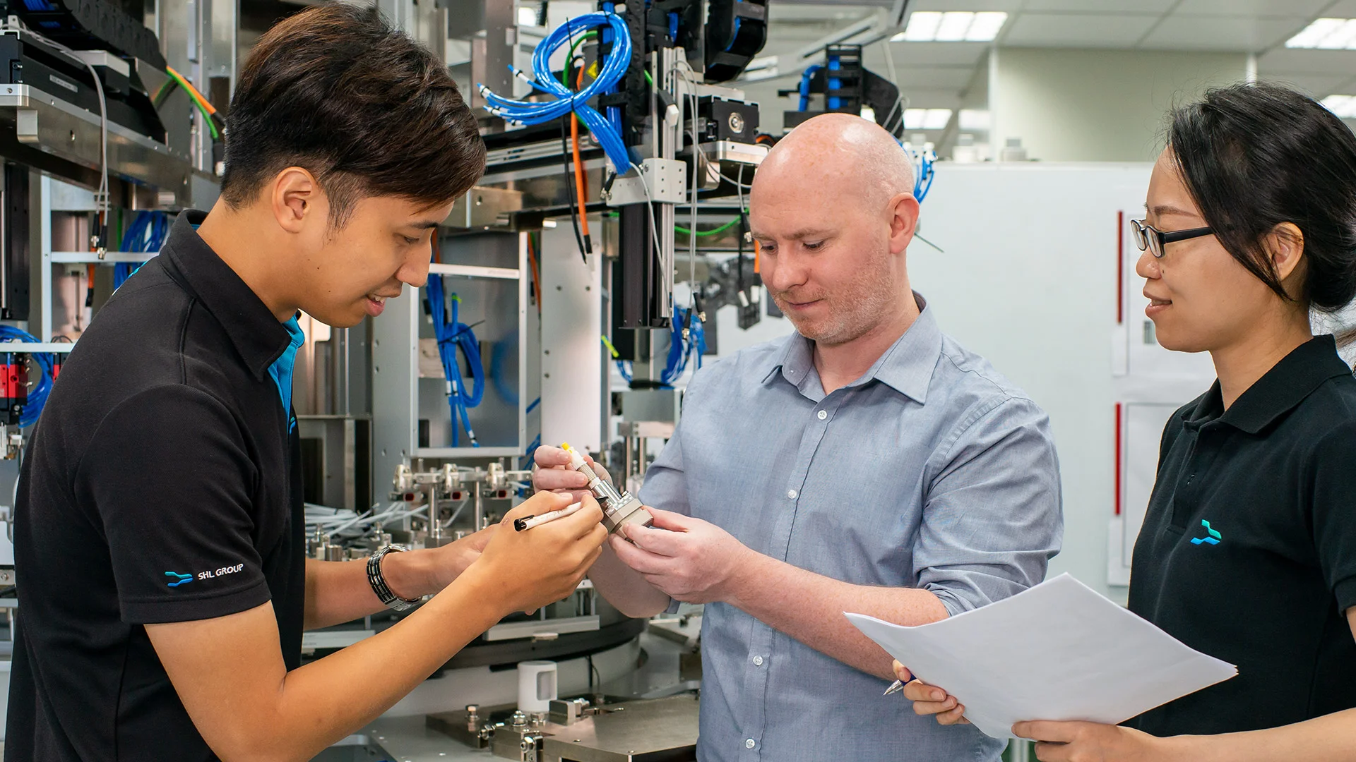 A group of people are working on a machine in a factory