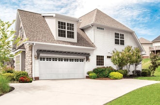 White residential garage door with windows, installed in a suburban family home