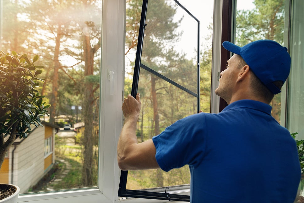 Man replacing a window screen