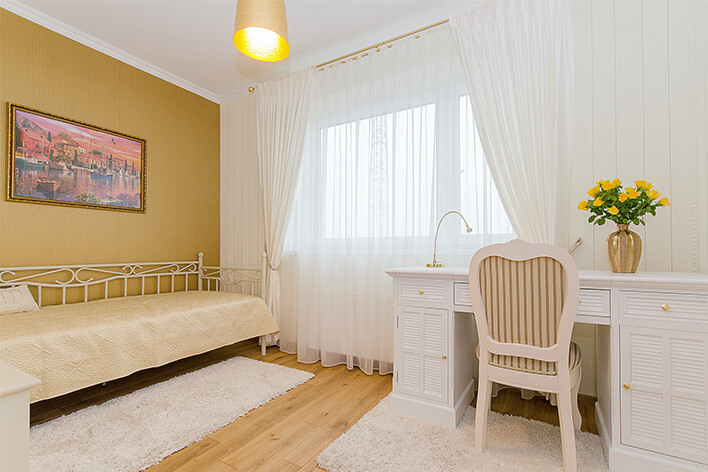 Feminine home office with white furniture and a large picture window