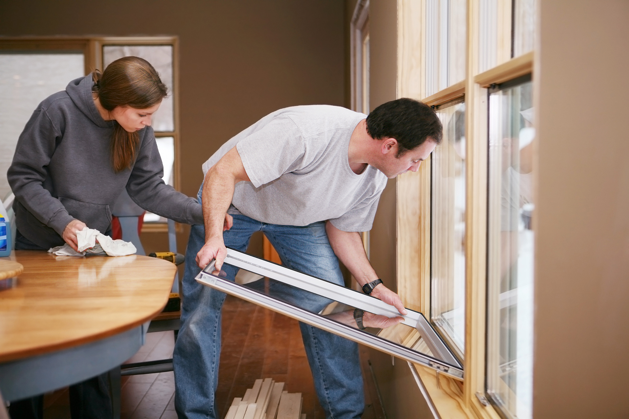 Man and woman replacing windows in their home on their own.