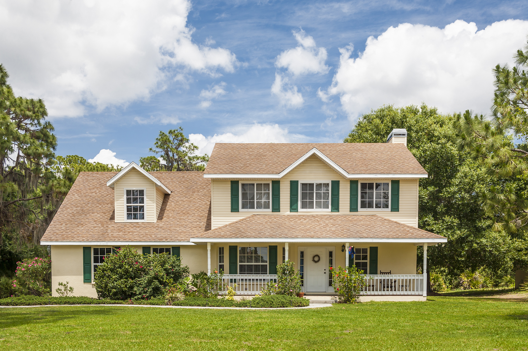 House with beige siding and green shutters