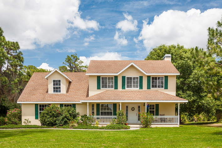 House with beige siding and green shutters
