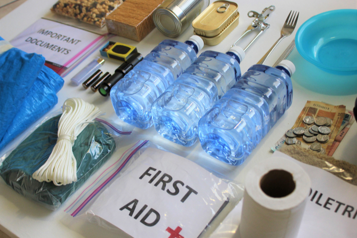 Emergency supplies to prepare your home for hurricane season that include water bottles, first aid kit, important documents, etc.