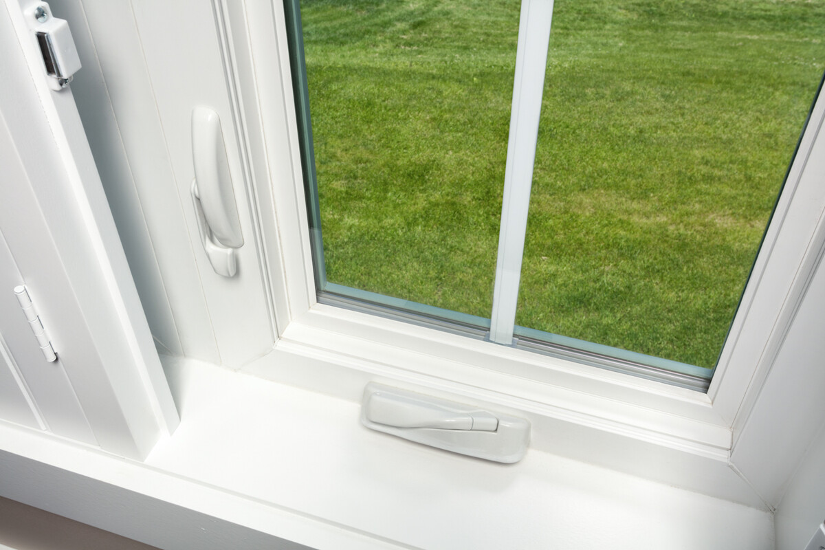 close-up of casement window hardware showing the locking handle and crank mechanism, designed for ease of use and durability