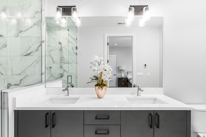 A modern white bathroom with marble tile and white countertops