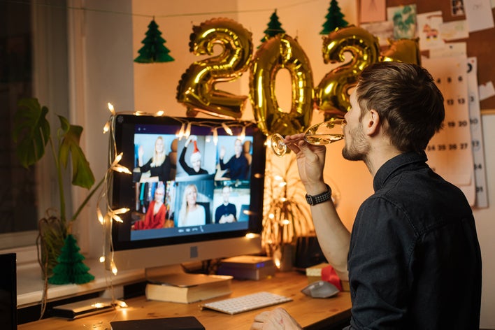 Man on a virtual computer call with friends celebrating New Year’s Eve