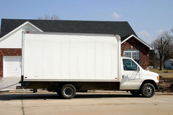 White moving truck in front of a new home.