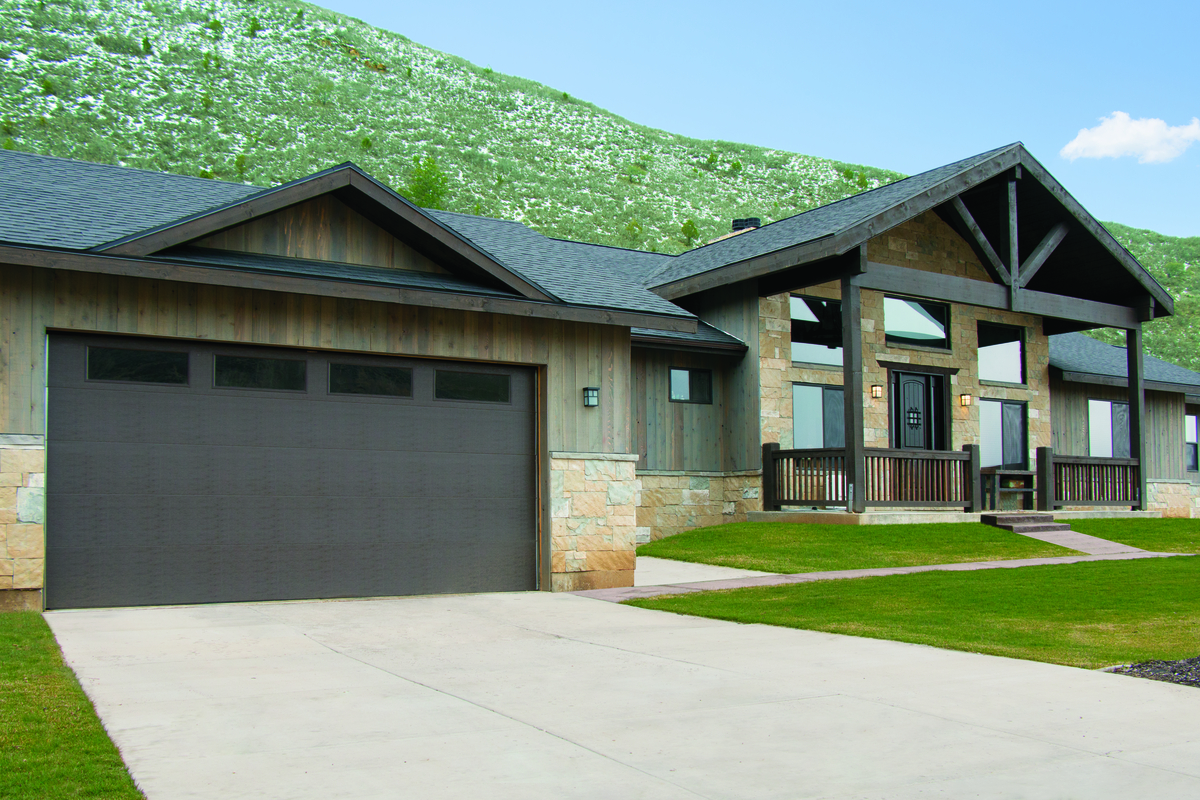 Black residential garage door with windows, installed in a suburban family home