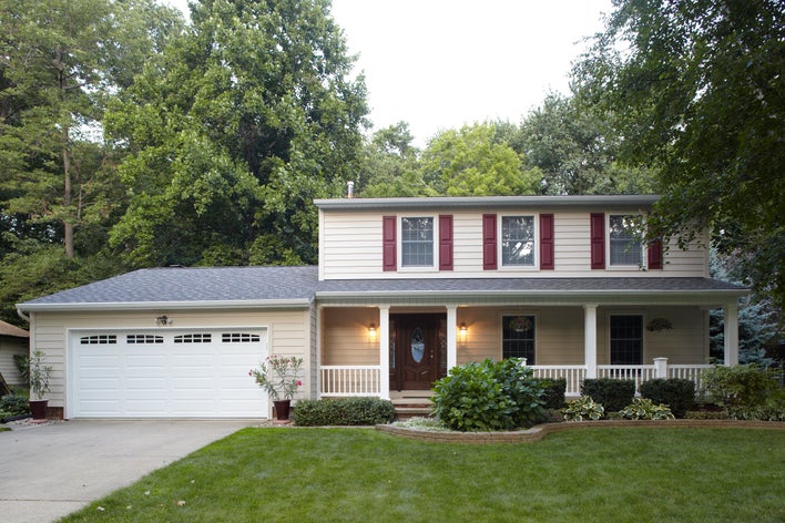 House with red shutters and beige siding.