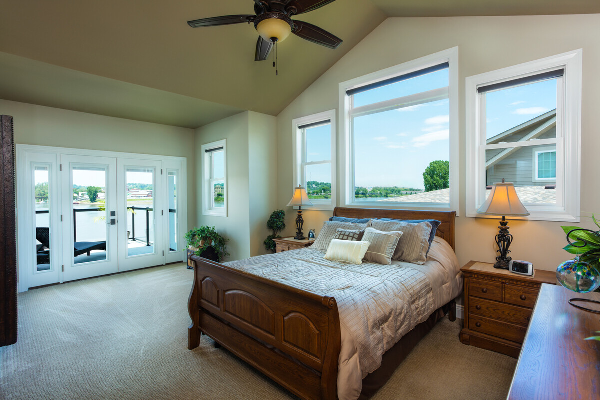 Interior scene with impact double hung and picture windows behind bed furniture