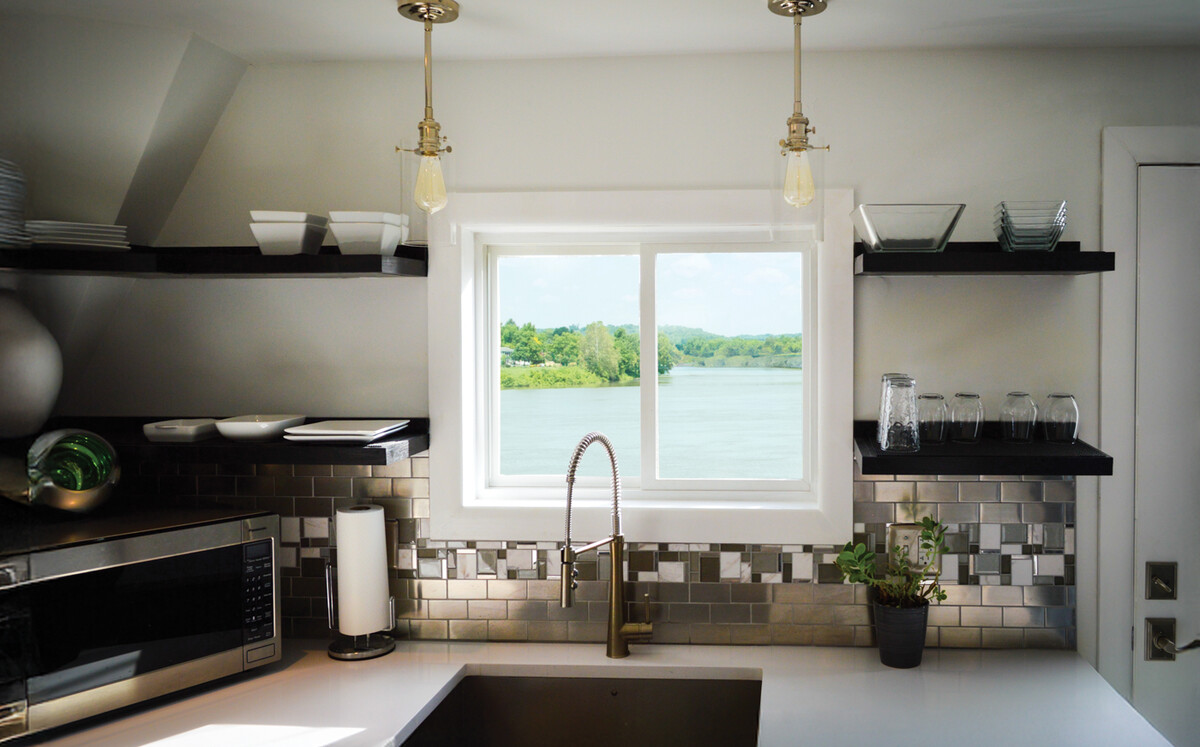 sliding window above kitchen sink offering scenic lake view, modern farmhouse design
