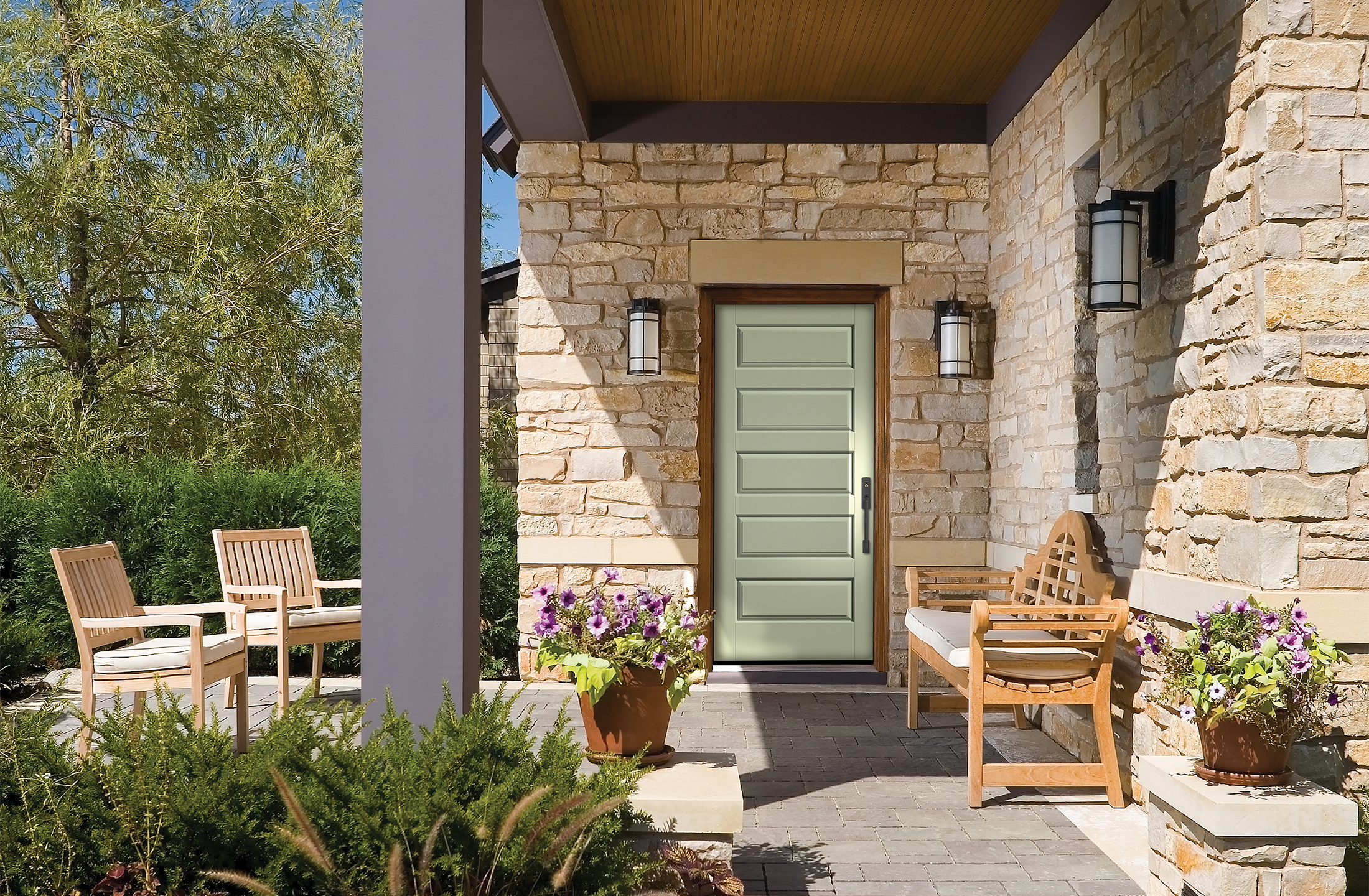 A Cypress colored Classic Craft Entry Door under a small stone porch in a well landscaped yard