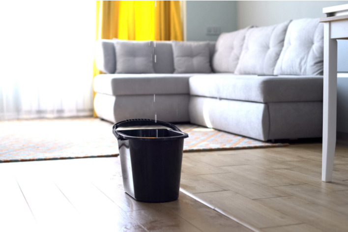 A bucket catches water from a leaky ceiling