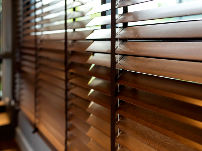 Dog-proof window blinds; these wooden blinds function as a privacy screen, blocking the view into a house.