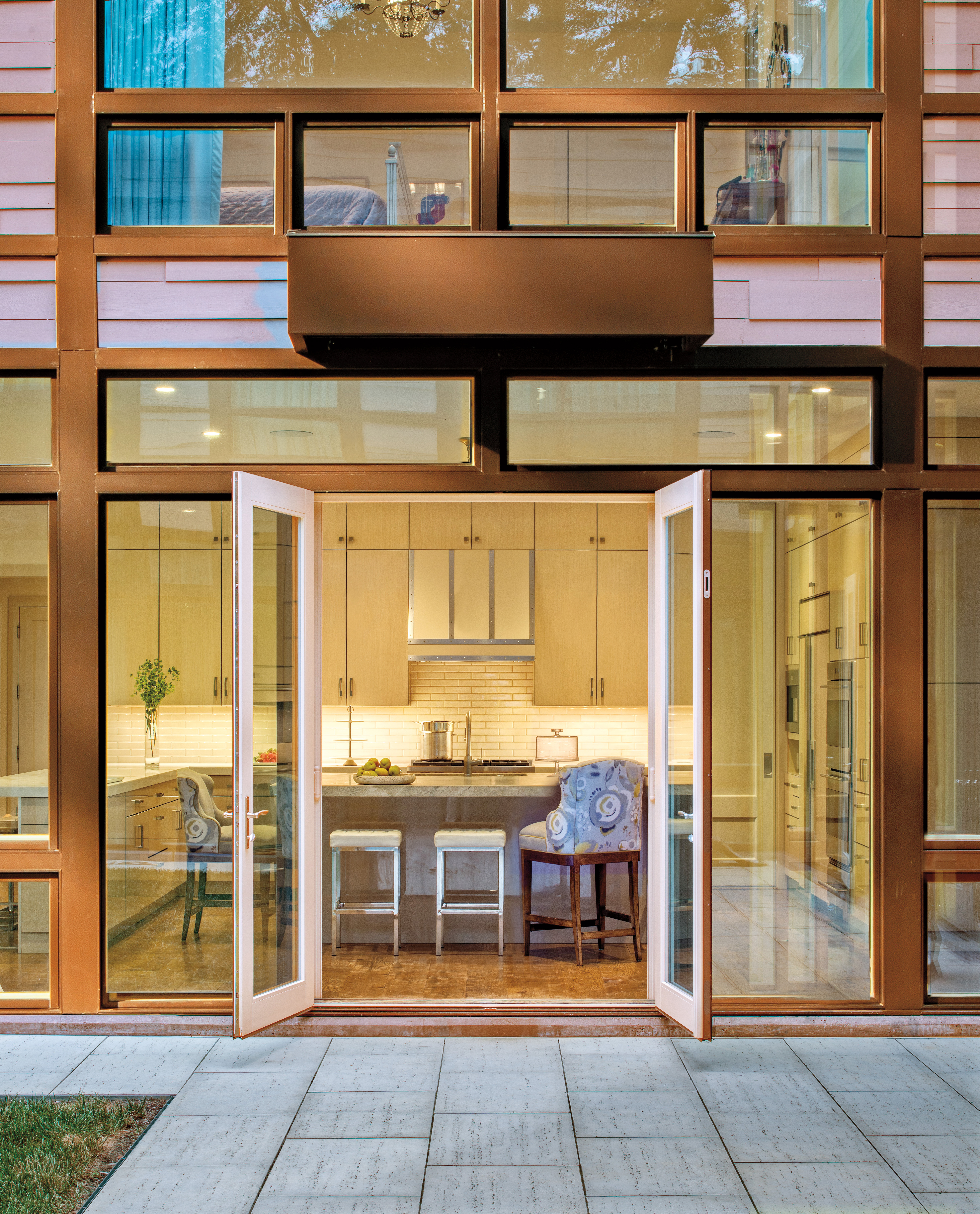 A hinged patio door with 2 functioning panels opened and connecting to a kitchen area