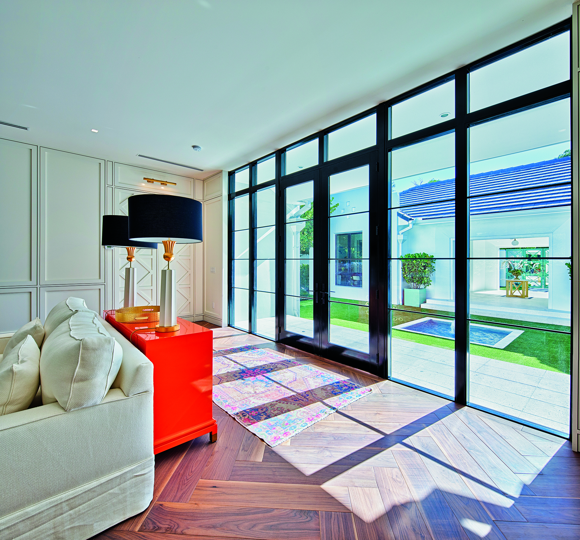 A black hinged patio door with 2 functioning panels in a living room.