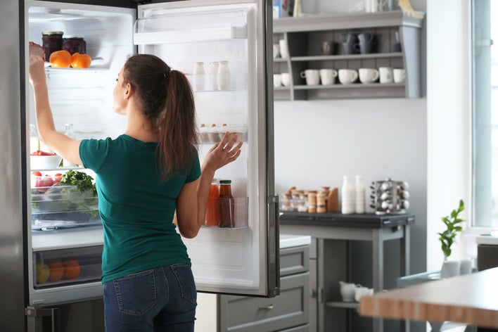 A woman preparing her home for hurricane season by lowering the temperature in her fridge A woman preparing her home for hurricane season by lowering the temperature in her fridge