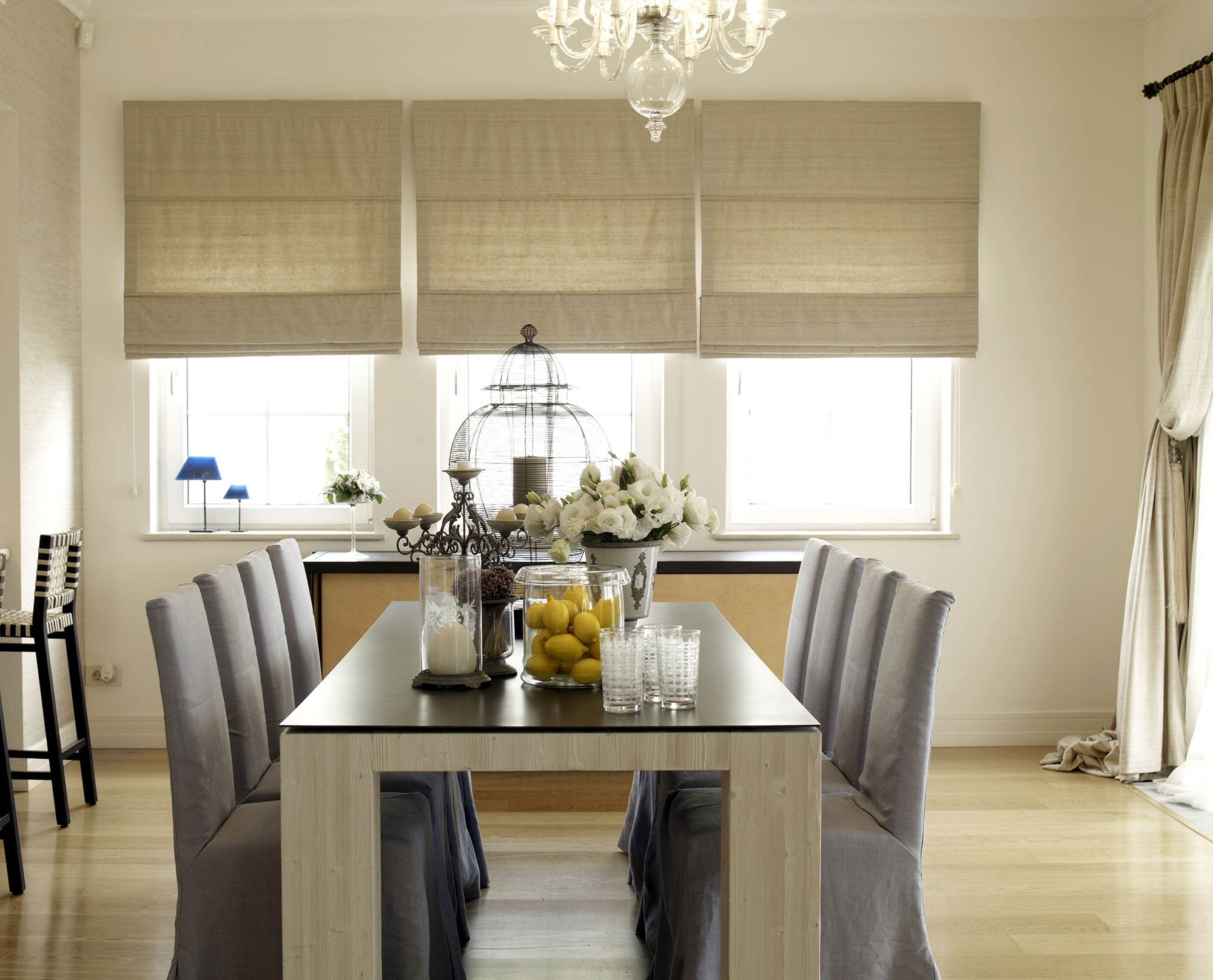 Roman shades on three dining room windows are pet-friendly window treatments.